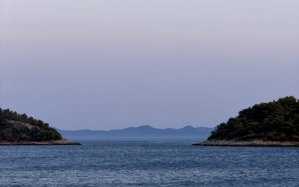 Otočki v morju pod mehkim večernim nebom