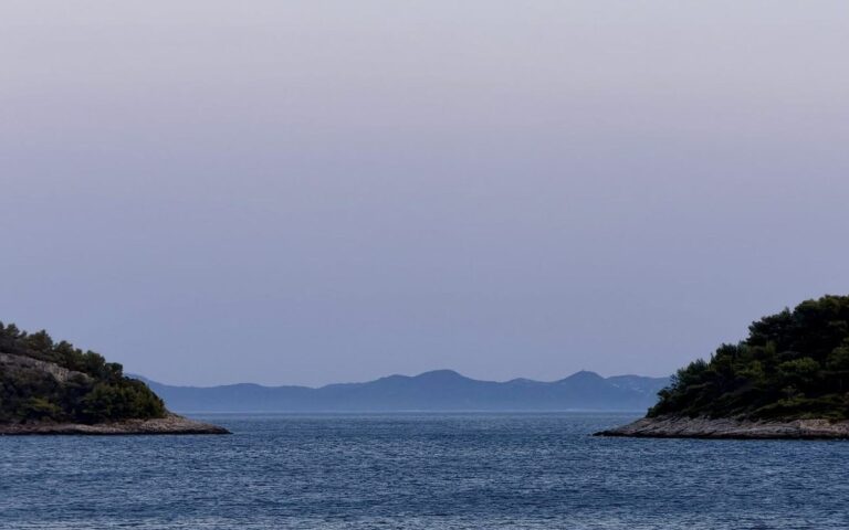 Otočki v morju pod mehkim večernim nebom