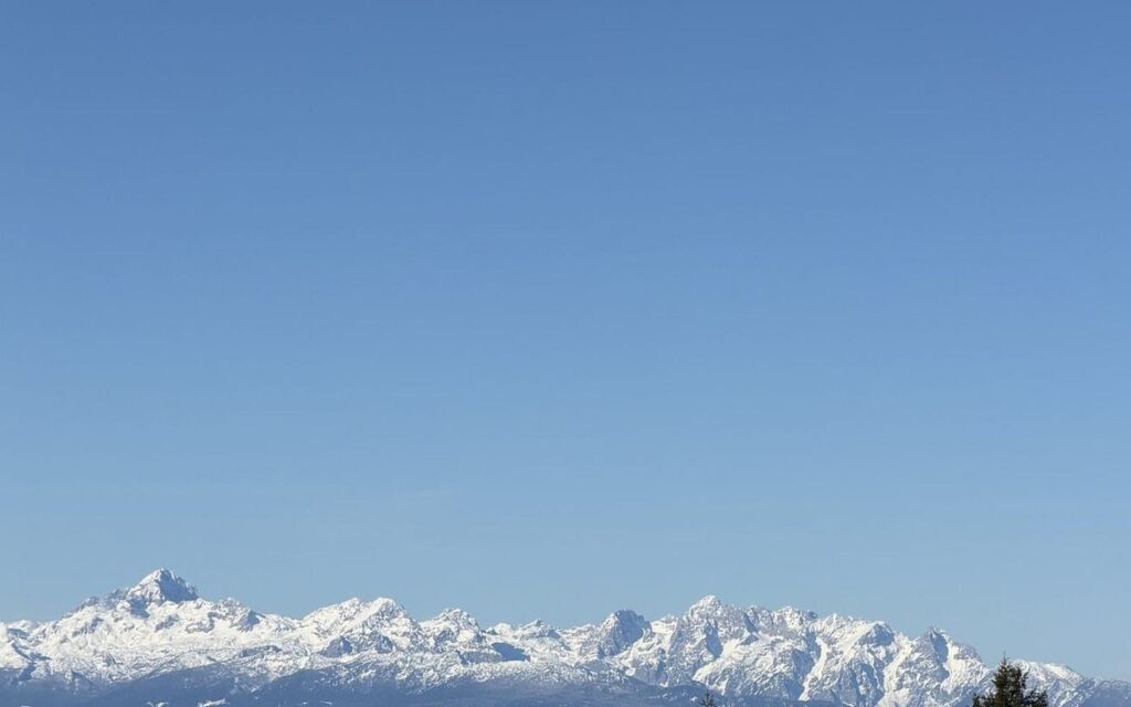Zasneženo gorovje nad meglenim obzorjem