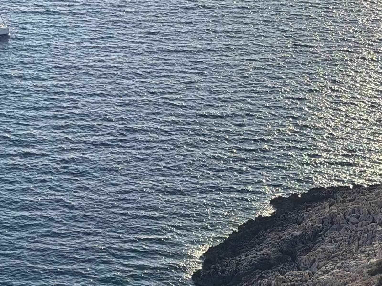 Jadrnica ob strmi skalnati obali