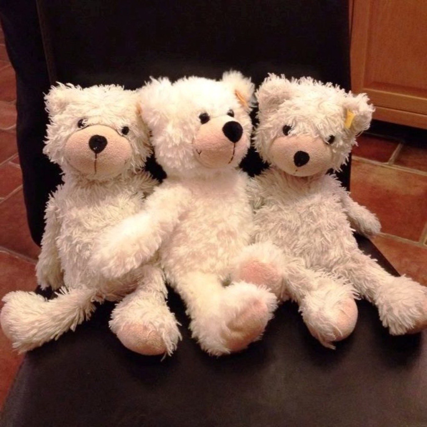 A child between two parents, each holding one hand